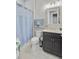 Well-lit bathroom features a vanity with dark cabinets, toilet, and a shower behind a patterned blue curtain at 366 Tupelo Lake Dr, Summerville, SC 29486