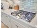Close-up of the kitchen cooktop featuring stainless steel appliances and white cabinets at 366 Tupelo Lake Dr, Summerville, SC 29486