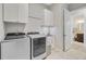 Functional laundry room with modern washer and dryer, sink, cabinets, and a view of an attached bath at 366 Tupelo Lake Dr, Summerville, SC 29486