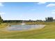 Picturesque pond with a water fountain, surrounded by green grass and trees on a sunny day at 366 Tupelo Lake Dr, Summerville, SC 29486