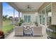 Relaxing screened-in porch with cozy seating, ceiling fan, and a tranquil view of the landscaped yard at 366 Tupelo Lake Dr, Summerville, SC 29486