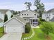 Aerial view showcasing a charming home with a detached garage, screened porch, and backyard patio at 3998 Capensis Ln, Ravenel, SC 29470