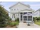 Charming home with a screened-in porch and a patio for outdoor entertaining, surrounded by lush landscaping at 3998 Capensis Ln, Ravenel, SC 29470