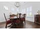 Formal dining room with hardwood floors, elegant chandelier, and wood furniture with red velvet chairs at 3998 Capensis Ln, Ravenel, SC 29470
