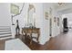 Elegant entryway with ornate mirror, decorative table, hardwood floors, and staircase to the second level at 3998 Capensis Ln, Ravenel, SC 29470