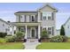 Lovely two-story home with well-manicured front lawn, covered porch with seating, and inviting curb appeal at 3998 Capensis Ln, Ravenel, SC 29470