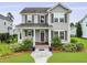 Charming two-story home with gray siding, shuttered windows, manicured lawn and a welcoming front porch with tasteful decor at 3998 Capensis Ln, Ravenel, SC 29470