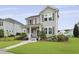 Attractive two-story home with gray siding, well-kept lawn, tasteful landscaping, and charming covered front porch at 3998 Capensis Ln, Ravenel, SC 29470