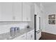 Kitchen featuring granite countertops, white cabinets, tiled backsplash and stainless steel refrigerator at 3998 Capensis Ln, Ravenel, SC 29470
