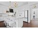 Spacious kitchen island with granite countertop, stool seating, and pendant lights, seamlessly connects to refrigerator at 3998 Capensis Ln, Ravenel, SC 29470
