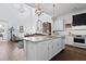 Bright, open kitchen flows into living room with white cabinets, granite countertops, and chandelier lighting at 3998 Capensis Ln, Ravenel, SC 29470