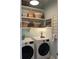 Functional laundry room with washer, dryer, and open shelving for storage and organization at 3998 Capensis Ln, Ravenel, SC 29470