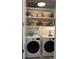 Bright laundry room features shelving, white washer and dryer, and tasteful decor accents at 3998 Capensis Ln, Ravenel, SC 29470