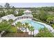 Aerial view of a large outdoor pool with palm trees and a gazebo-style pool house at 3998 Capensis Ln, Ravenel, SC 29470