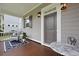 Inviting front porch featuring a seating area with a wicker chair and a marble table at 3998 Capensis Ln, Ravenel, SC 29470