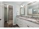 Bathroom features a dual sink vanity with granite countertops, a walk-in shower, and modern fixtures at 410 Yacht Harbor Ct # 410, Isle of Palms, SC 29451