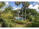Community pool surrounded by tropical greenery and various palm trees at 410 Yacht Harbor Ct # 410, Isle of Palms, SC 29451