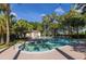 Community pool with clear blue water, lounge chairs, and lush tropical landscaping under sunny skies at 410 Yacht Harbor Ct # 410, Isle of Palms, SC 29451
