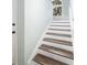 Stairway with white risers, wooden treads, and a window at the top offers a bright transition between floors at 410 Yacht Harbor Ct # 410, Isle of Palms, SC 29451