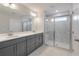 Bathroom featuring double sinks, large vanity, shower with glass door and marble tile at 422 Duskywing Dr, Goose Creek, SC 29445
