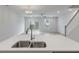 Kitchen island with stainless sink and quartz countertop overlooks the spacious living area with backyard access at 422 Duskywing Dr, Goose Creek, SC 29445