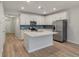 Well-lit kitchen features white cabinets, stainless steel appliances, an island, and stylish blue backsplash at 422 Duskywing Dr, Goose Creek, SC 29445