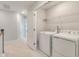 Bright laundry room with white washer, dryer, storage shelving, and neutral paint at 422 Duskywing Dr, Goose Creek, SC 29445
