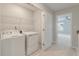 An upstairs laundry room features a washer, dryer, shelving, and modern design near the bedroom at 422 Duskywing Dr, Goose Creek, SC 29445