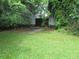 Spacious backyard with grass, mature trees, concrete pad, and a wooden fence that offers privacy at 47 Oswego St, Charleston, SC 29403