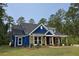 Charming home featuring blue siding, stone accents, and a welcoming front porch with wooden pillars at 6093 Sourwood Trl, Ridgeville, SC 29472