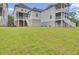 View of the backyard featuring two-story homes with balconies, stairs, and a spacious green lawn under a blue sky at 617 Du Bois Dr, Johns Island, SC 29455