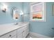 Bright bathroom features a large vanity with storage, an oval mirror, and a window at 727 Sonny Boy Ln, Johns Island, SC 29455