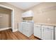 Bright laundry room with laminate floors, white cabinets, washer, and dryer for added convenience at 727 Sonny Boy Ln, Johns Island, SC 29455