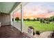 Spacious covered porch with scenic views of the lush green lawn and colorful sunset at 727 Sonny Boy Ln, Johns Island, SC 29455