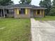 Cozy brick home featuring yellow shutters, a well-maintained lawn, and a paved driveway at 7713 Suzanne Dr, North Charleston, SC 29418
