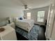 Cozy bedroom with white furniture, ceiling fan, and blue accent rug at 81 Sandbar Ln # 28, Folly Beach, SC 29439