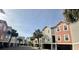 Street view of colorful townhomes with ground-level parking and lush palm trees, creating a relaxed and inviting community vibe at 81 Sandbar Ln # 28, Folly Beach, SC 29439
