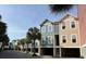 Street view showcasing colorful townhome exteriors and mature palm trees, offering picturesque curb appeal in a coastal community at 81 Sandbar Ln # 28, Folly Beach, SC 29439