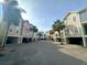 Street view showcasing colorful townhomes with palm trees, offering picturesque curb appeal in a vibrant coastal community at 81 Sandbar Ln # 28, Folly Beach, SC 29439