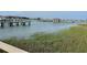 Beautiful waterfront view of pier near buildings with blue water and green marsh grass at 81 Sandbar Ln # 28, Folly Beach, SC 29439