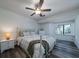 Comfortable bedroom boasts a ceiling fan, hardwood floors, and natural light from the shuttered window at 855 Club Cottage Rd, Edisto Island, SC 29438
