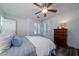 Bright bedroom with ceiling fan, plantation shutters, and a dark wood dresser at 855 Club Cottage Rd, Edisto Island, SC 29438