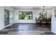 Sunlit dining area featuring wood floors, neutral walls, and large windows with views at 855 Club Cottage Rd, Edisto Island, SC 29438