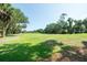Scenic view of a well-manicured golf course with mature trees under a clear blue sky at 855 Club Cottage Rd, Edisto Island, SC 29438