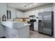 Bright kitchen with white cabinets, stainless steel appliances, and a breakfast bar at 855 Club Cottage Rd, Edisto Island, SC 29438