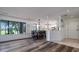 Open floorplan with wood floors, large windows, and an adjacent kitchen at 855 Club Cottage Rd, Edisto Island, SC 29438