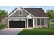 Charming single-story home with gray siding, stone accents, black garage door, and well-maintained landscaping at 8605 Connor Ct, North Charleston, SC 29406