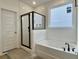 Modern bathroom featuring a shower with glass doors, a soaking tub, and white tile at 8629 Connor Ct, North Charleston, SC 29406