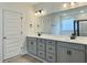 Bright bathroom features a double sink vanity with gray cabinets and modern fixtures, illuminated by stylish lighting at 8629 Connor Ct, North Charleston, SC 29406