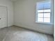 Bright bedroom features a door, neutral carpet and a large window with exterior view at 8629 Connor Ct, North Charleston, SC 29406